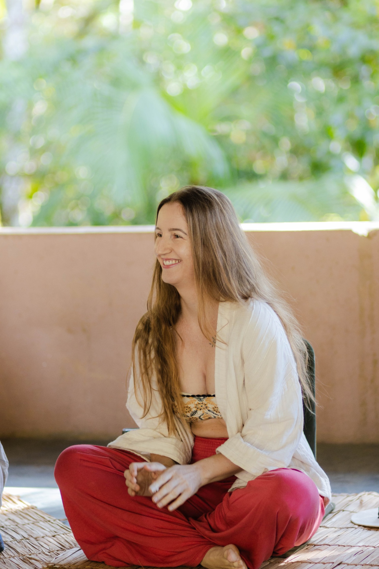 Camila sentada, sorrindo, presença serena